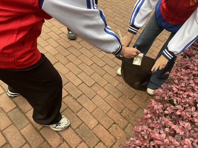 志愿者在T3一楼小花园捡烟盒