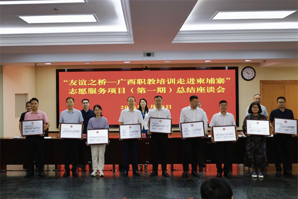 Qiu Fuming (center) receives the plaque honoring the universitys active participation in the Bridge of Friendship project