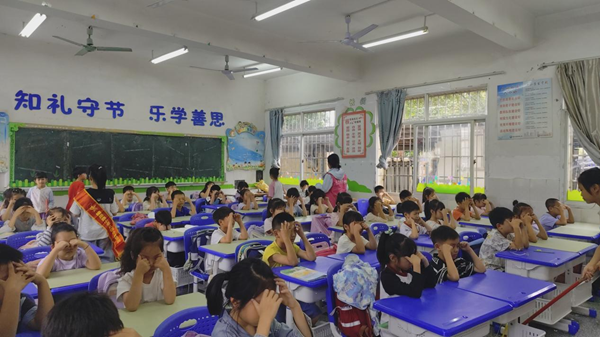 志愿者在协助老师检查眼保健操情况 志愿者在协助老师检查眼保健操情况